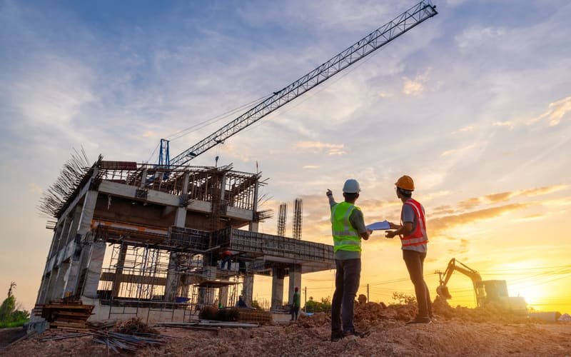 Industrial structure under construction with a tower crane at dusk